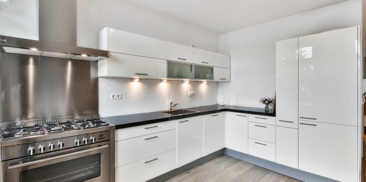 Gloss white L-shaped kitchen layout with a range cooker